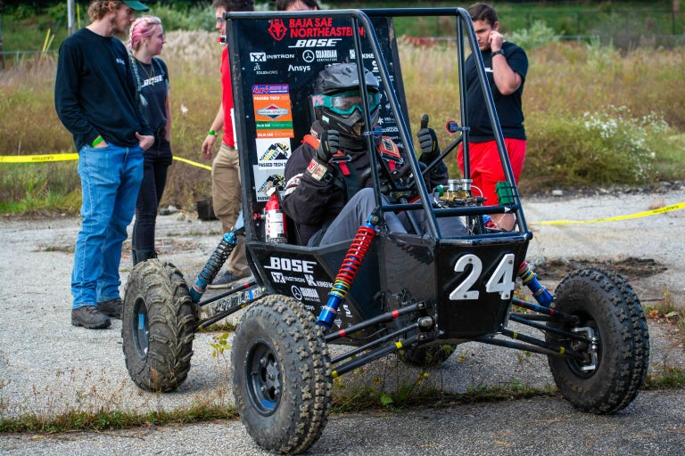 Team members around the vehicle